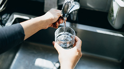 Person pouring water from tap