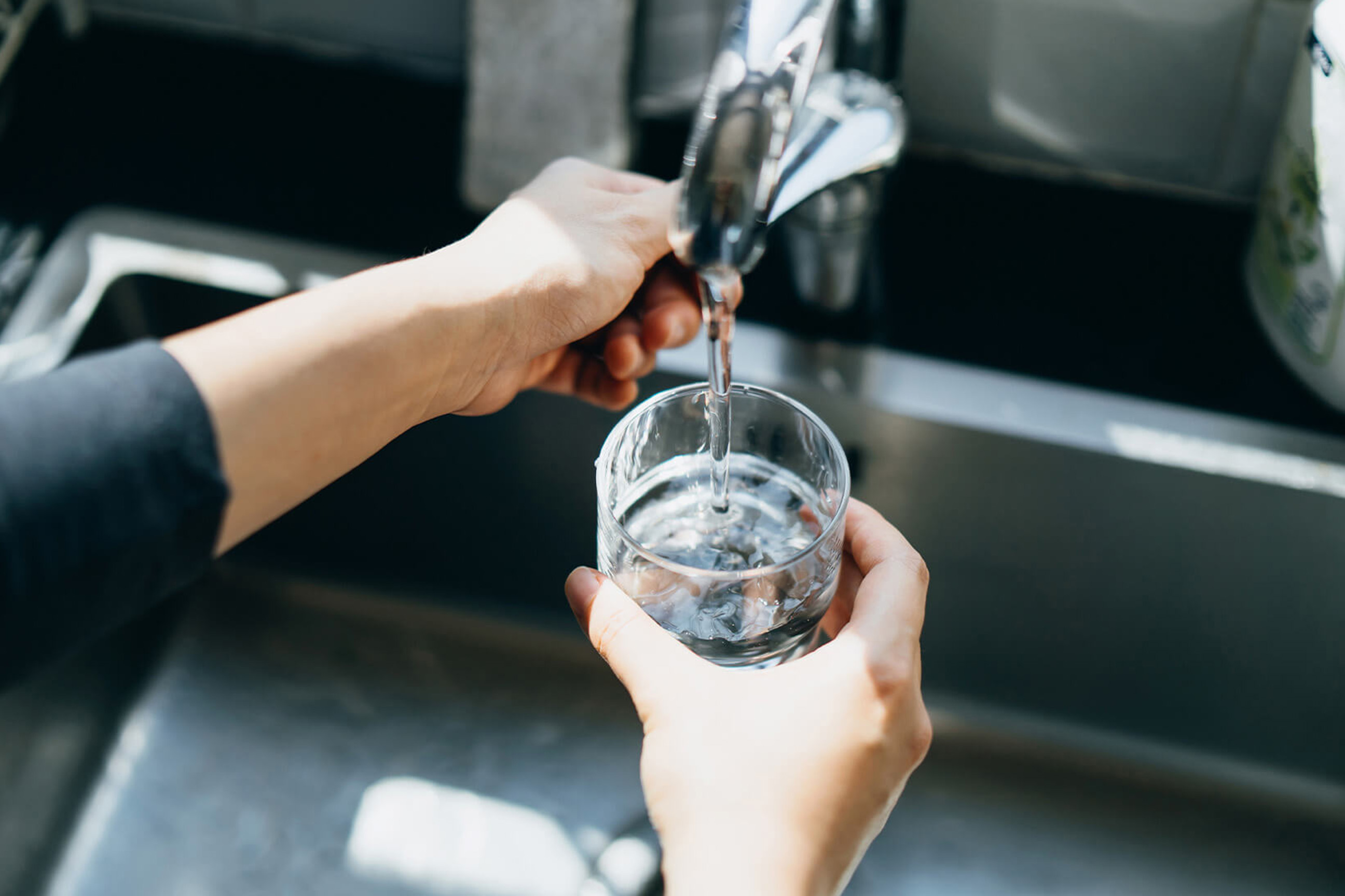Person pouring water from tap