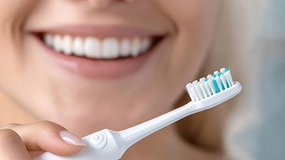 uśmiechnięta osoba ze szczoteczką do zębów