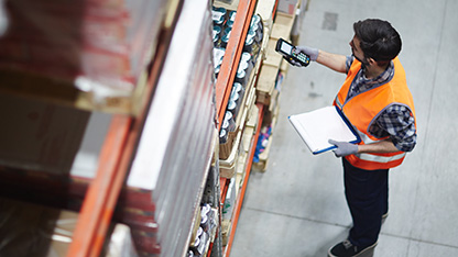 Pracownik w PPE sprawdzający stan zapasów